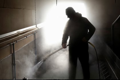 A pig producer cleaning out a pig facility. Not only internal biosecurity, but also external biosecurity is important to avoid pathogens from coming in. A pig producer cleaning out a pig facility. Not only internal biosecurity, but also external biosecurity is important to avoid pathogens from coming in.
